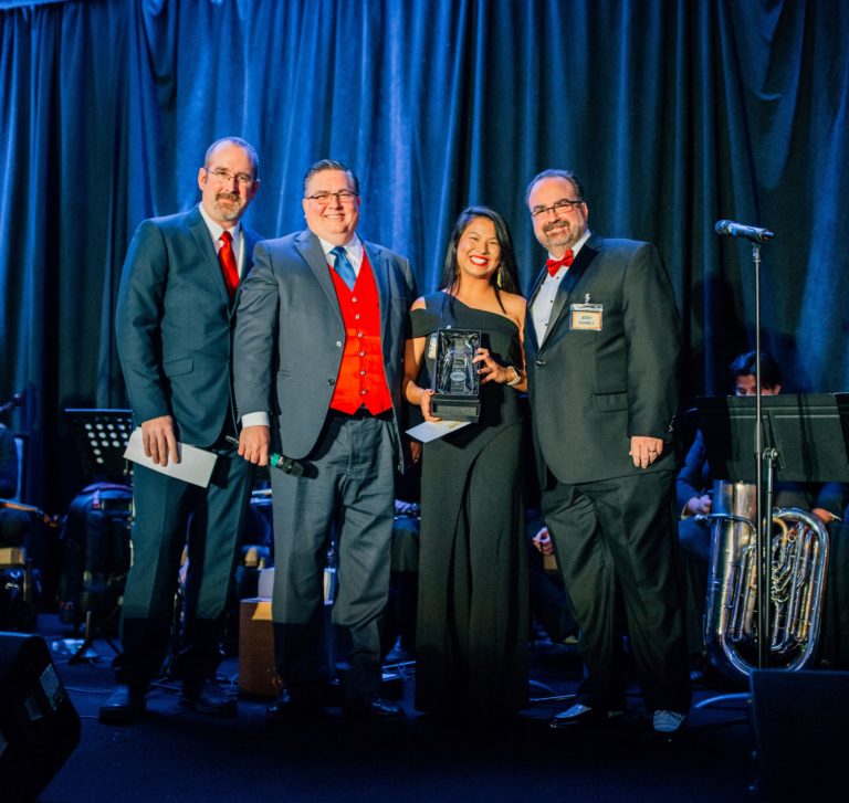 Four People on Stage with Award